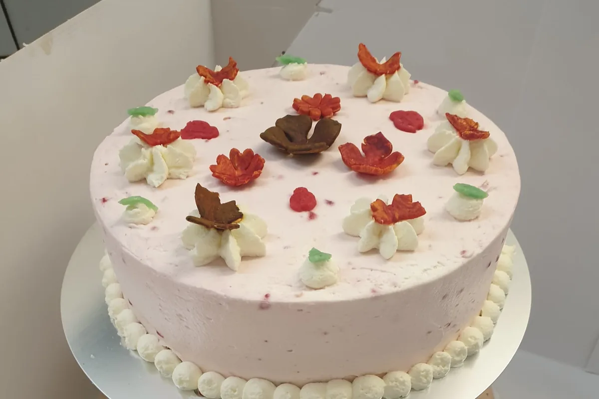 Eine zweistöckige Torte mit Blütendekor aus Sahne.