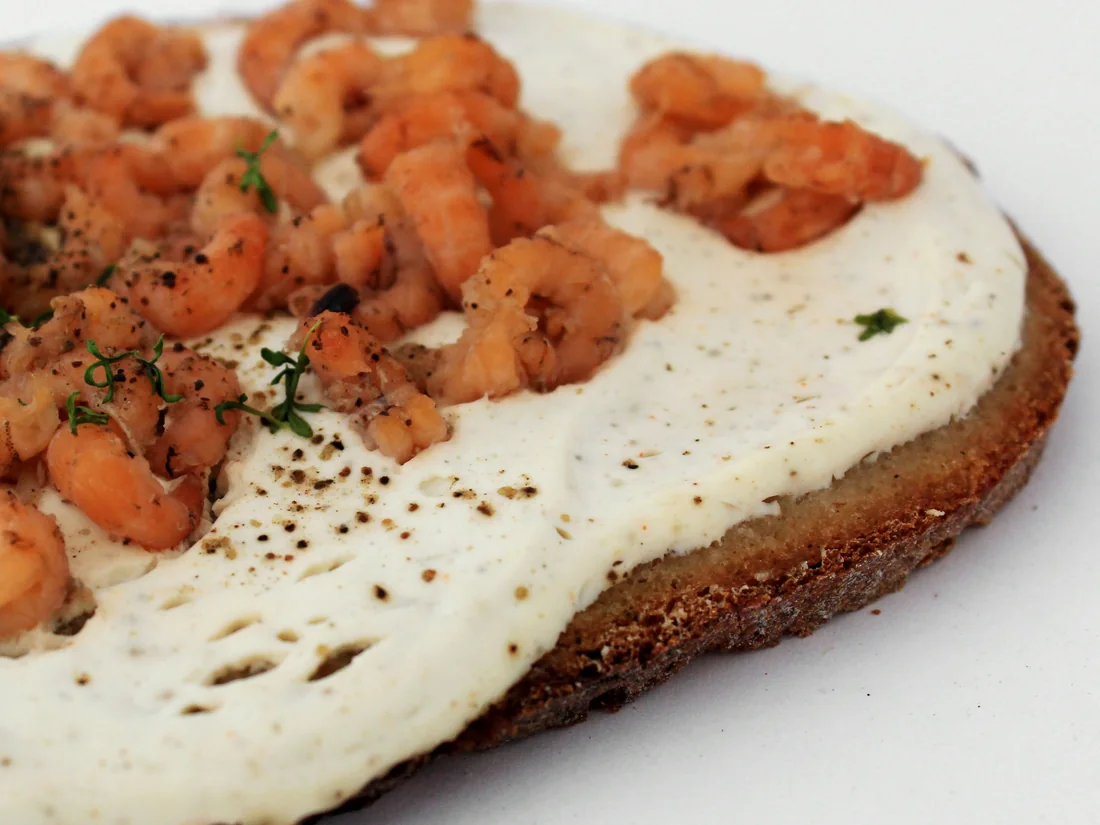 Geröstetes Mischbrot mit Schmand und Nordseekrabben.