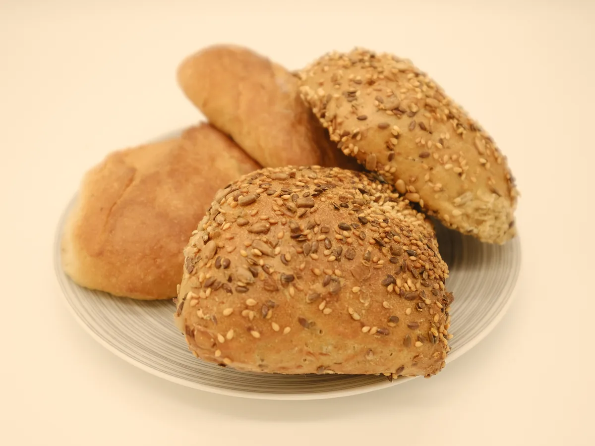 Helle Brötchen und Körnerbrötchen auf einem Teller.